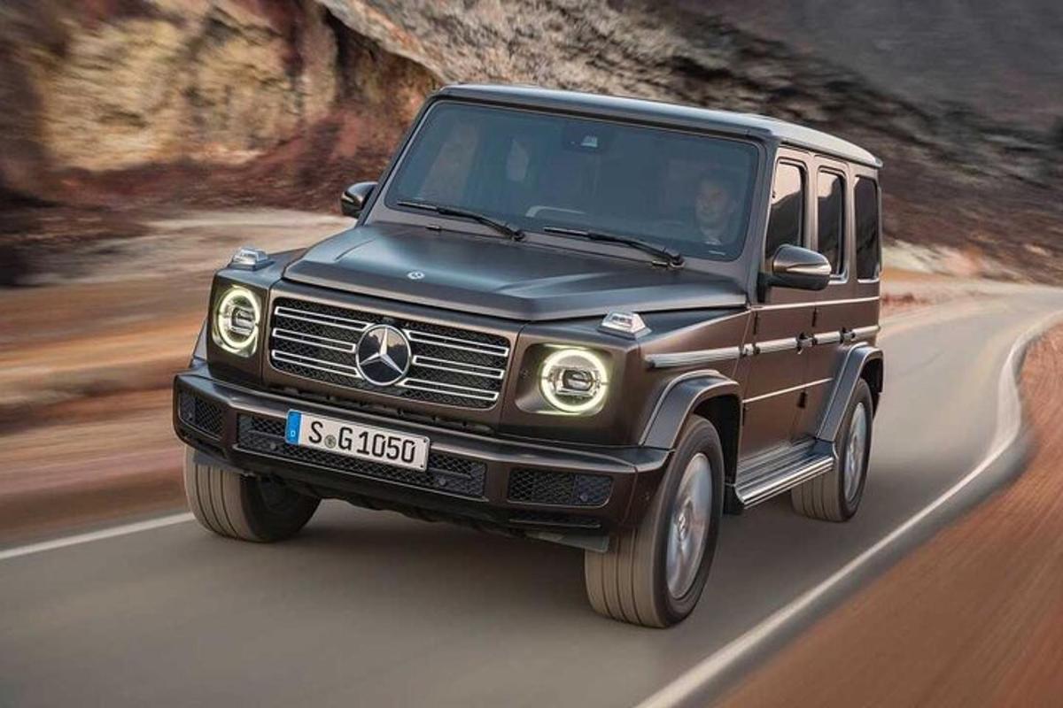 un camion Mercedes Benz nero che percorre una strada