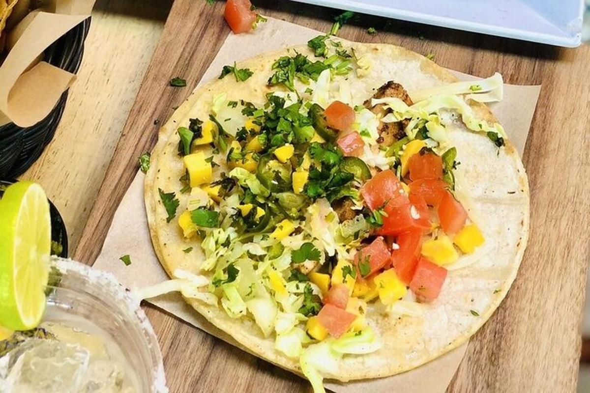 en tortilla-pizza med grønnsaker på et trebord