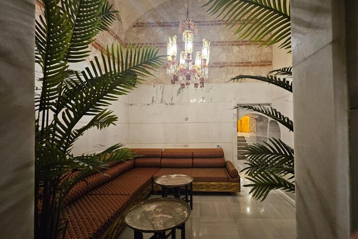 a room with a couch and two tables and a chandelier