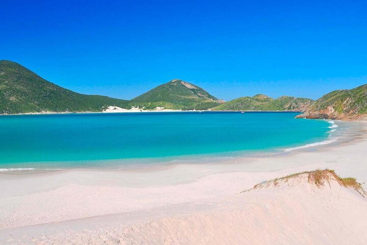 пляж з блакитною водою та горами на задньому плані