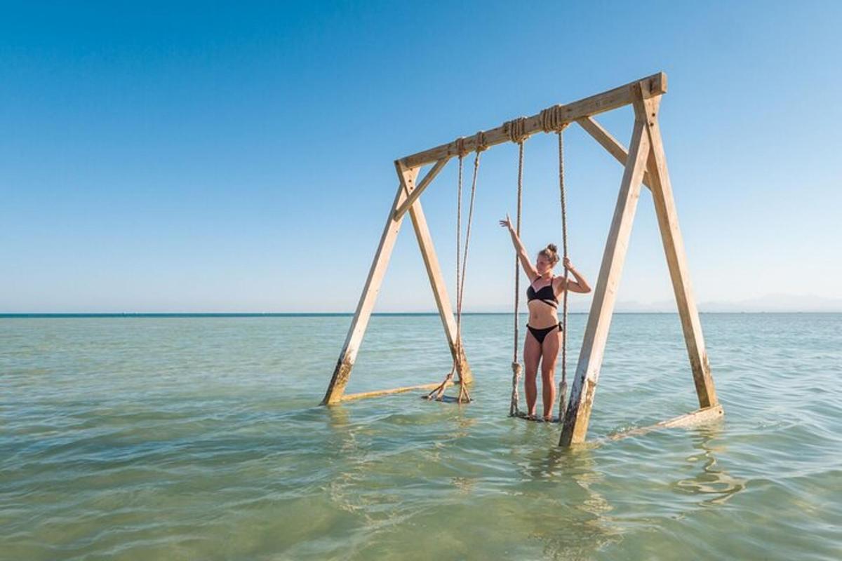 Una mujer está de pie sobre un marco de madera en el agua.