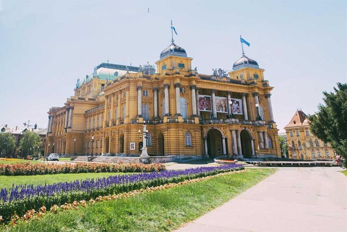 un gran edifici amb flors morades al davant