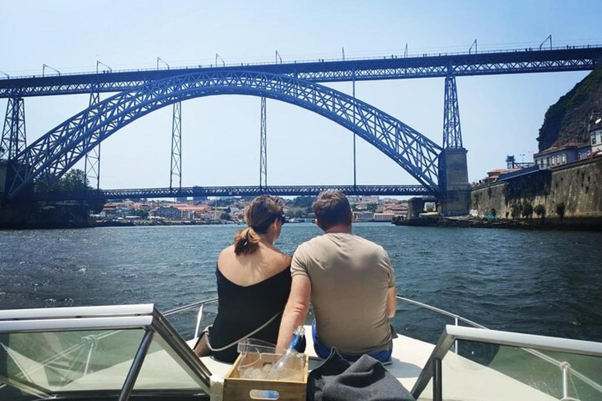 a man and woman sitting on a boat in front of a bridge