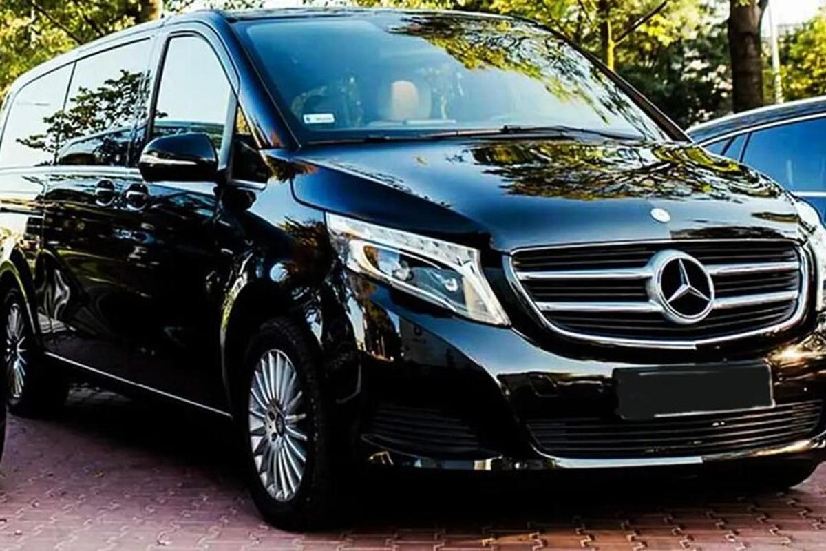 en svart Mercedes-Benz-bil parkerad på en parkeringsplats
