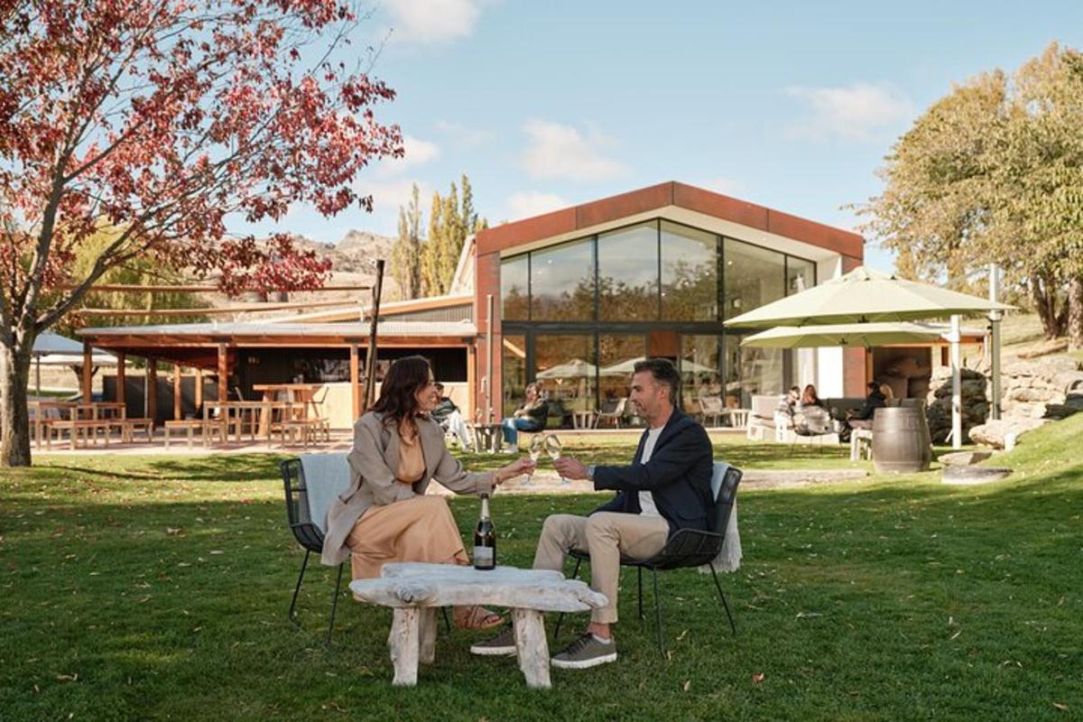 a man and woman sitting at a table in a park