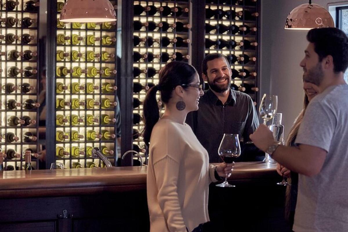 a group of people standing at a bar with wine glasses