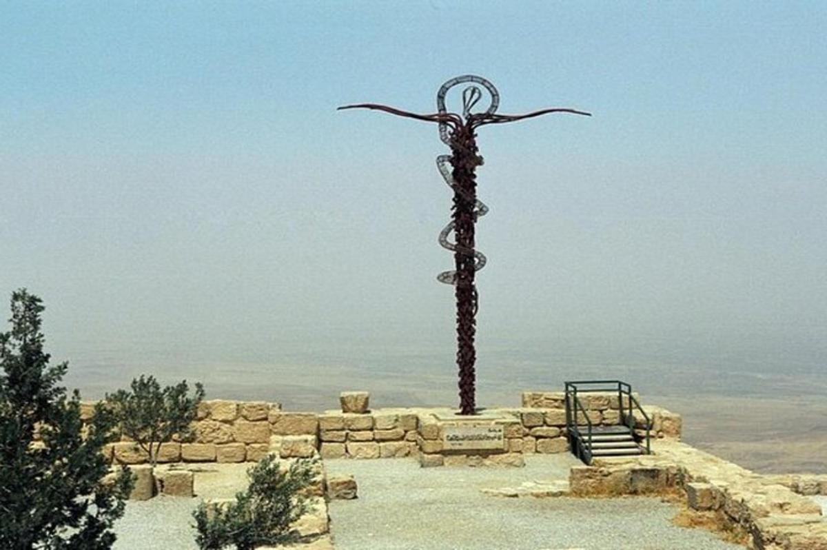 a statue of a cross on top of a hill