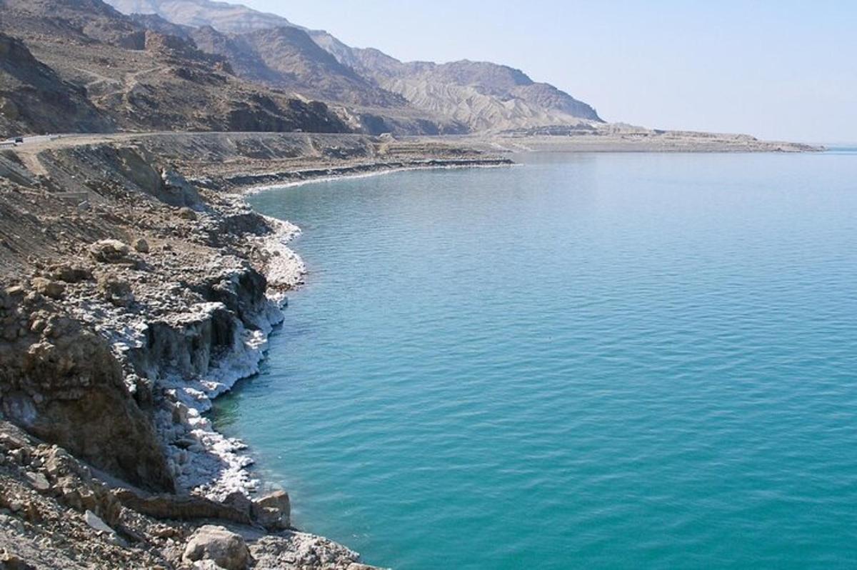 a large body of water next to a mountain