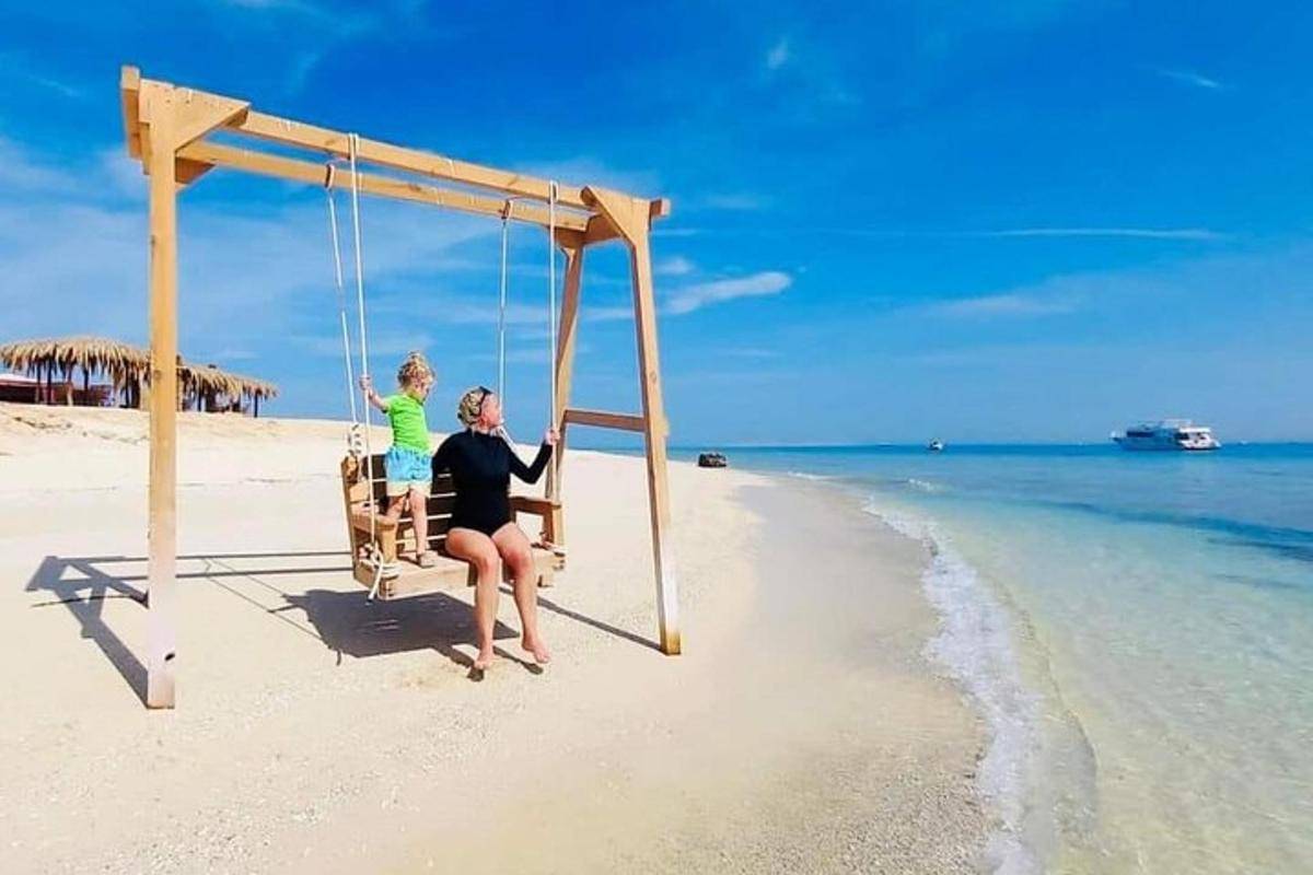 a woman sitting in a swing on the beach