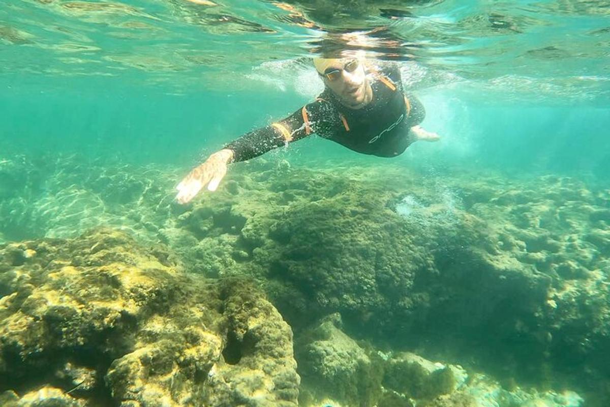 a woman is swimming in the clear water