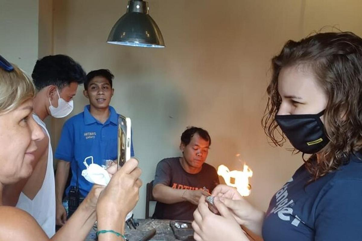 a group of people standing around a table looking at a mirror