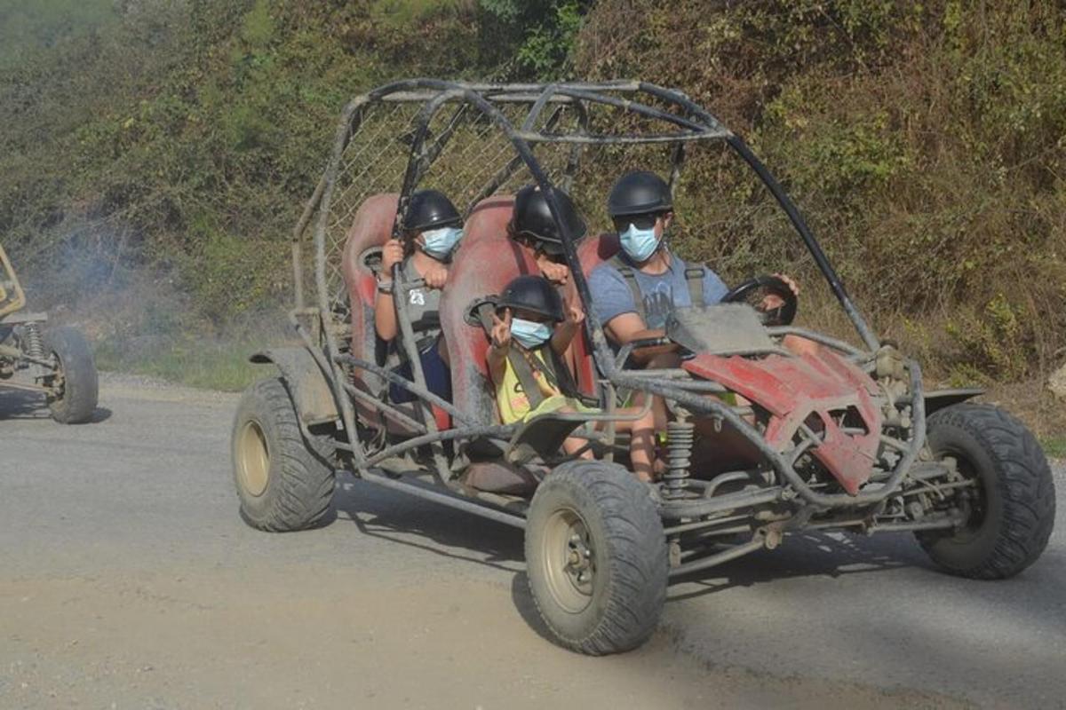 un grup de oameni care călătoresc într-un vehicul cu patru roți