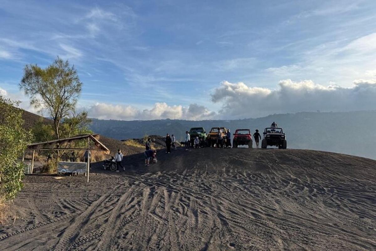 un gruppo di auto parcheggiate in cima a una strada sterrata