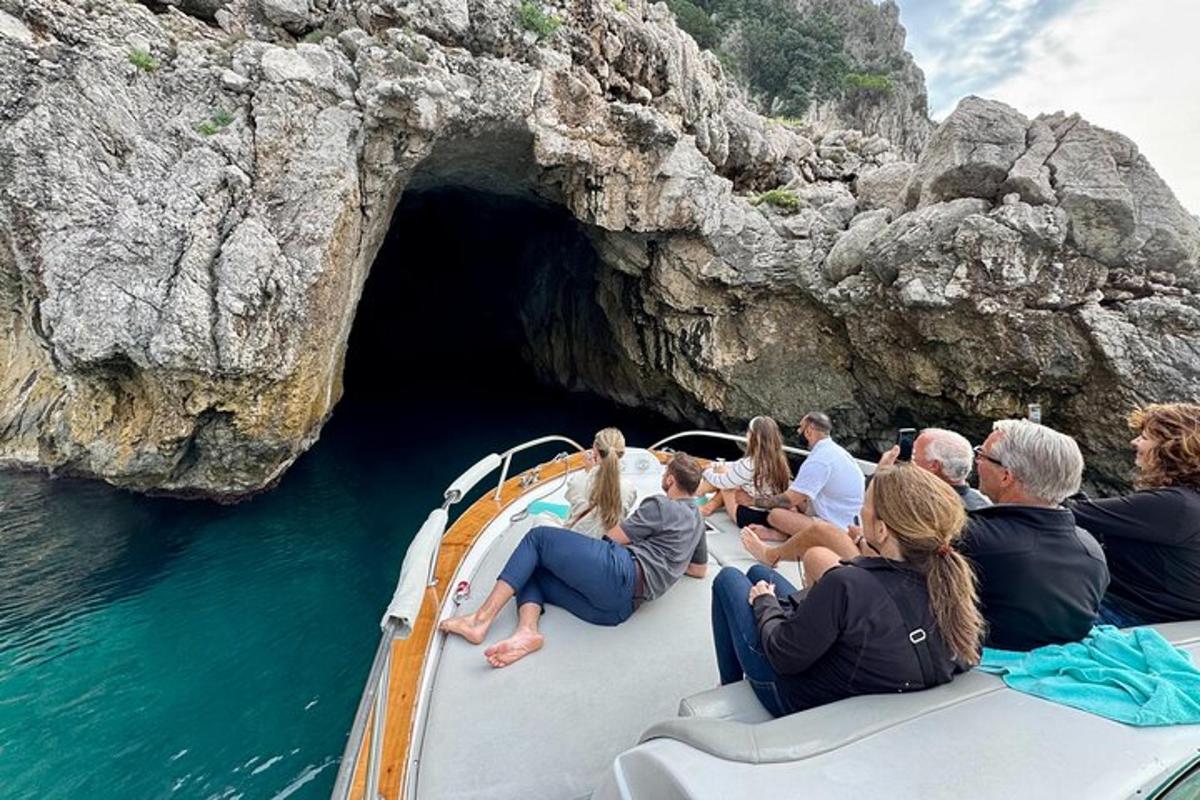 Un grupo de personas sentadas en un bote frente a una cueva.