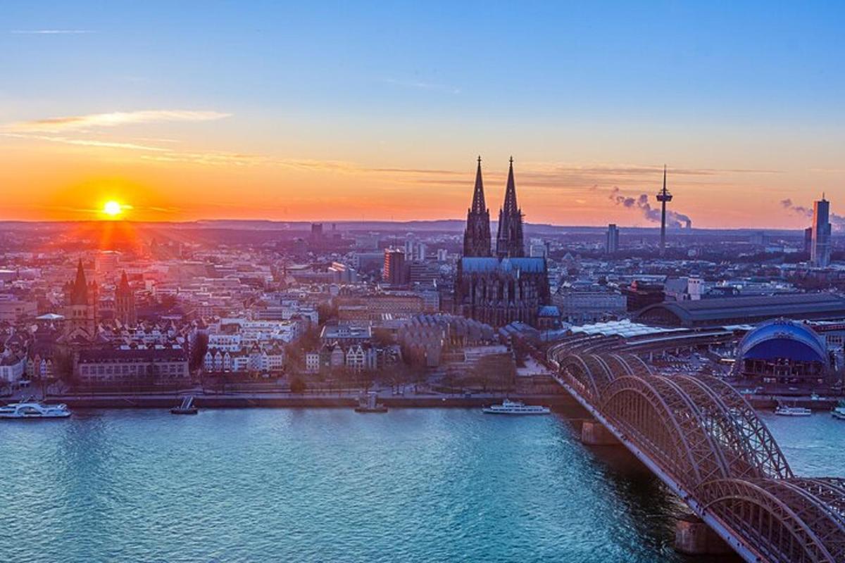 ein Sonnenuntergang über einer Stadt mit einem Fluss und einer Brücke