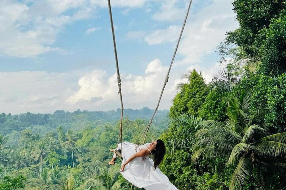 một người phụ nữ đang đu mình trên một sợi dây xích đu trong rừng