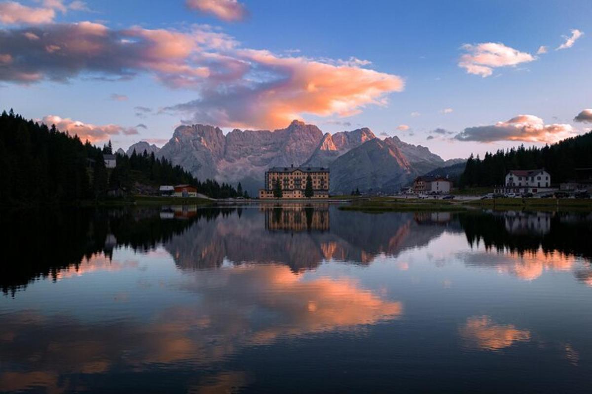 reflexia unei clădiri pe un lac cu munți