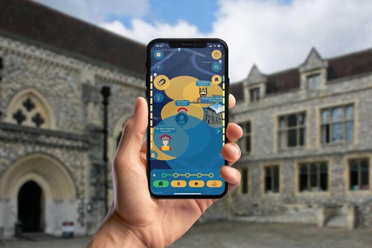 osoba držící mobilní telefon před budovou