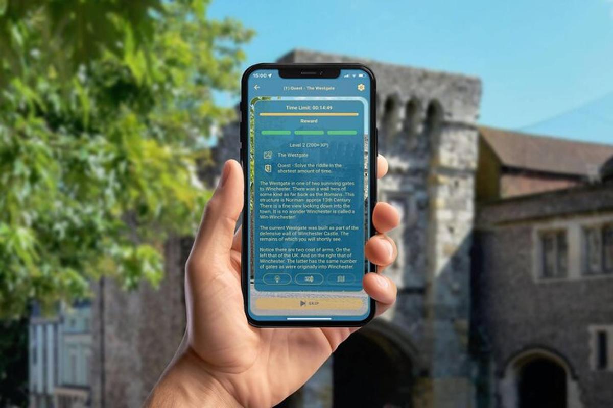 ruka držící mobilní telefon před budovou