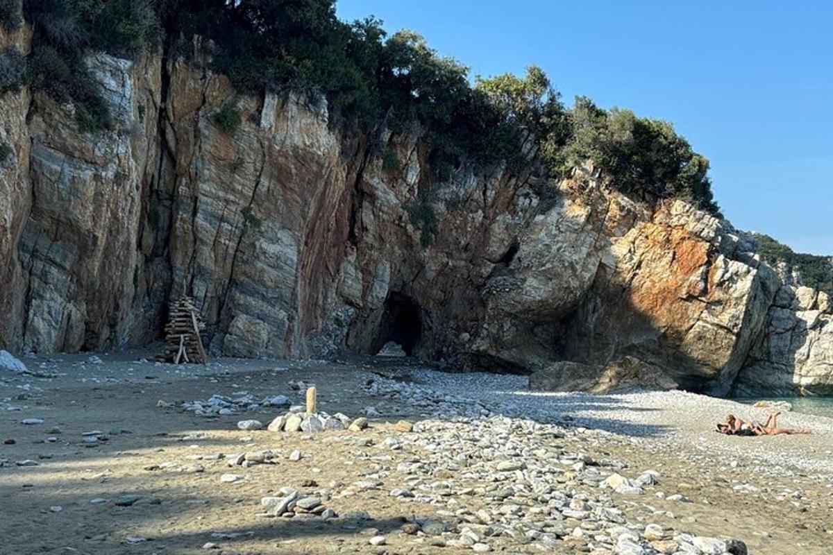 a rocky beach with a cave in the side of a cliff