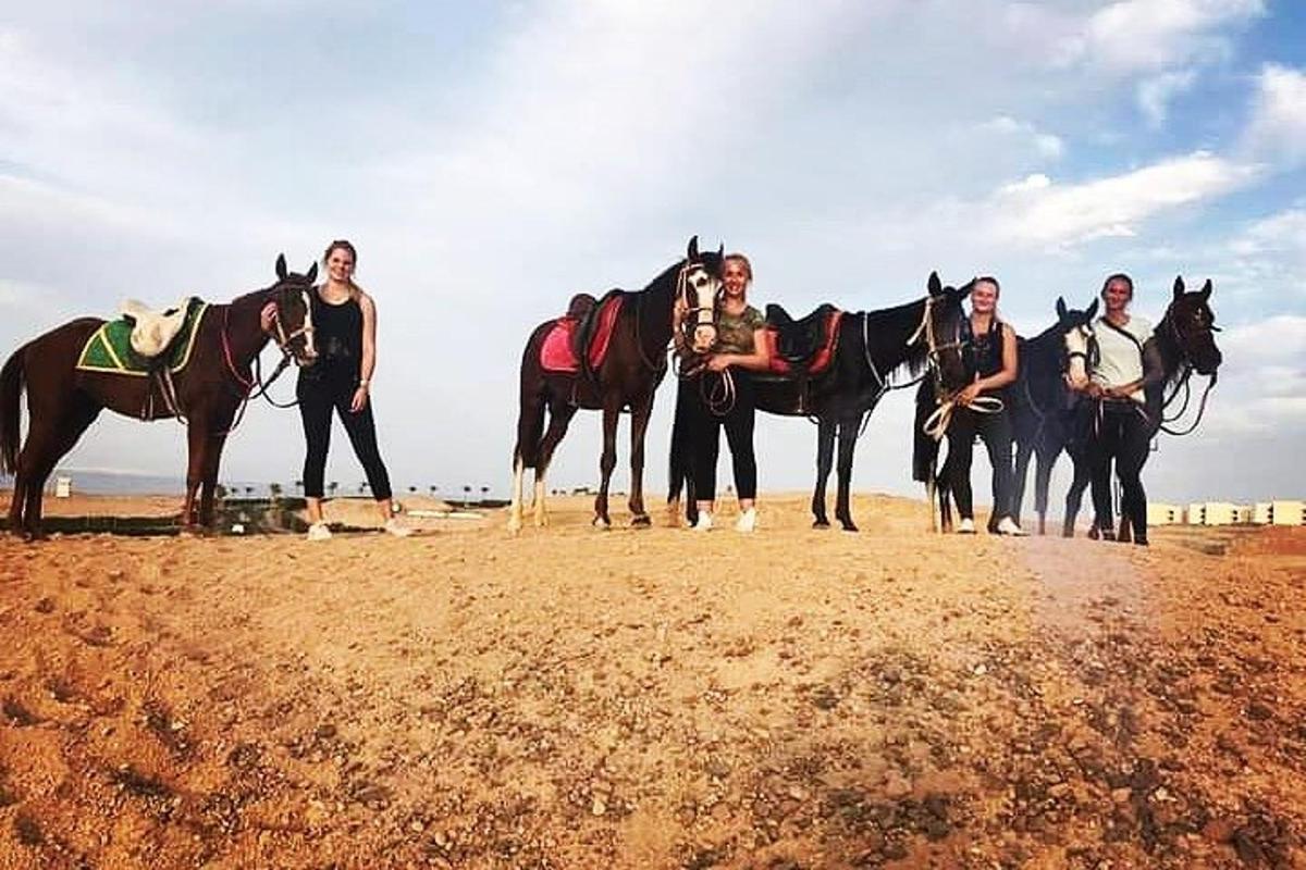 um grupo de pessoas em pé ao lado de um grupo de cavalos