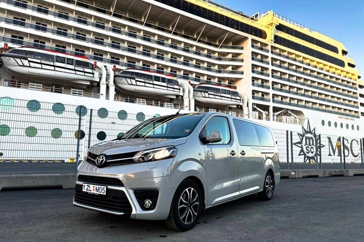 un'auto argentata parcheggiata davanti a una nave da crociera