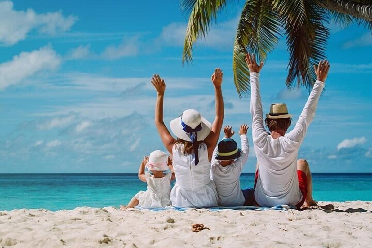 a family sitting on the beach with their hands in the air