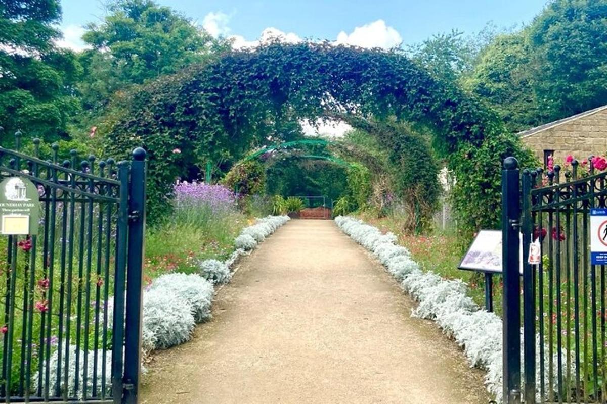a garden with an arch and a dirt road