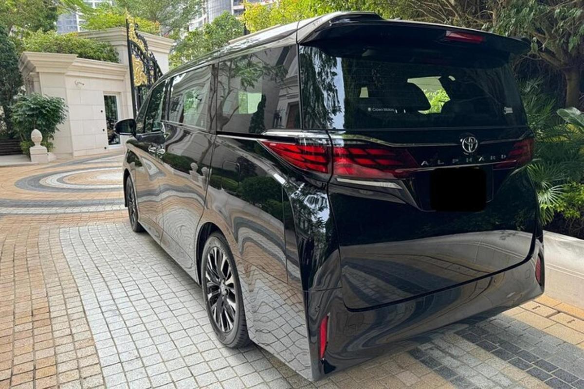 um carro preto estacionado em uma rua de tijolos
