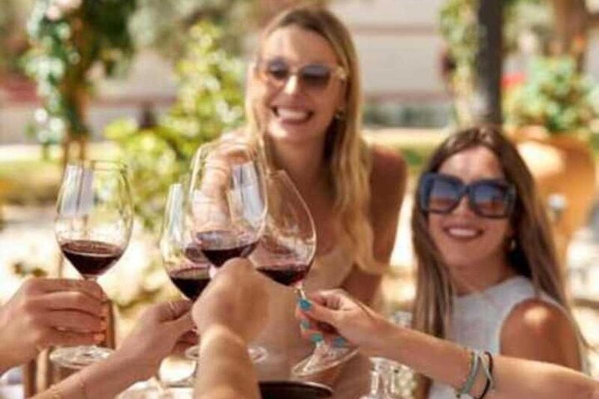 un gruppo di donne che tengono in mano bicchieri di vino