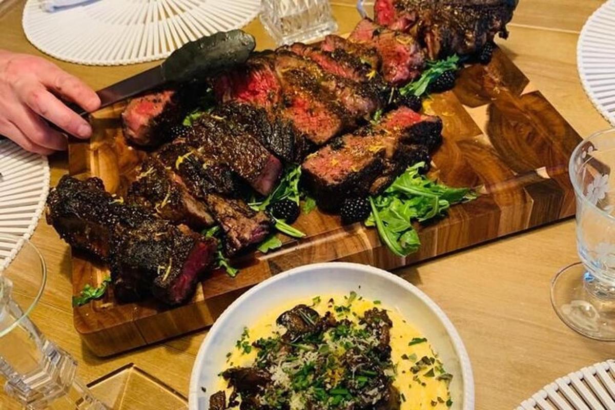 un tavolo con un tagliere con carne e verdure
