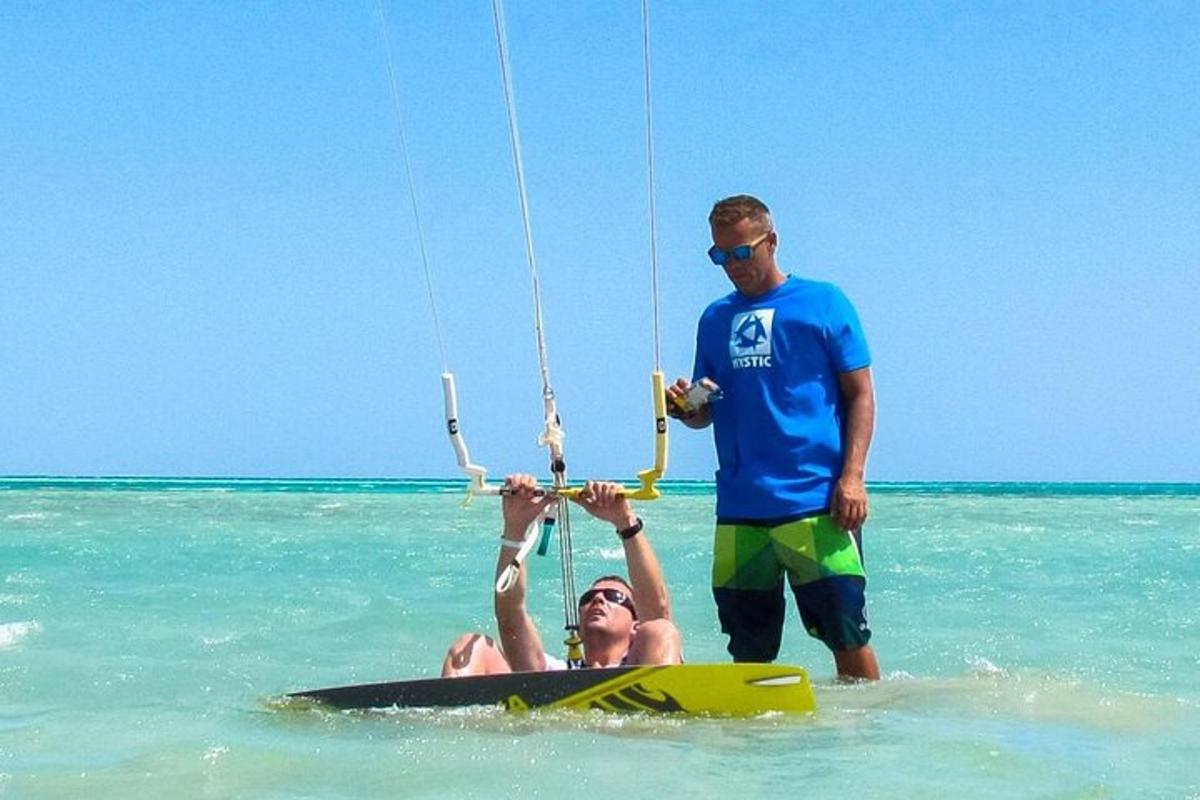 a man and a woman in the water with a kite