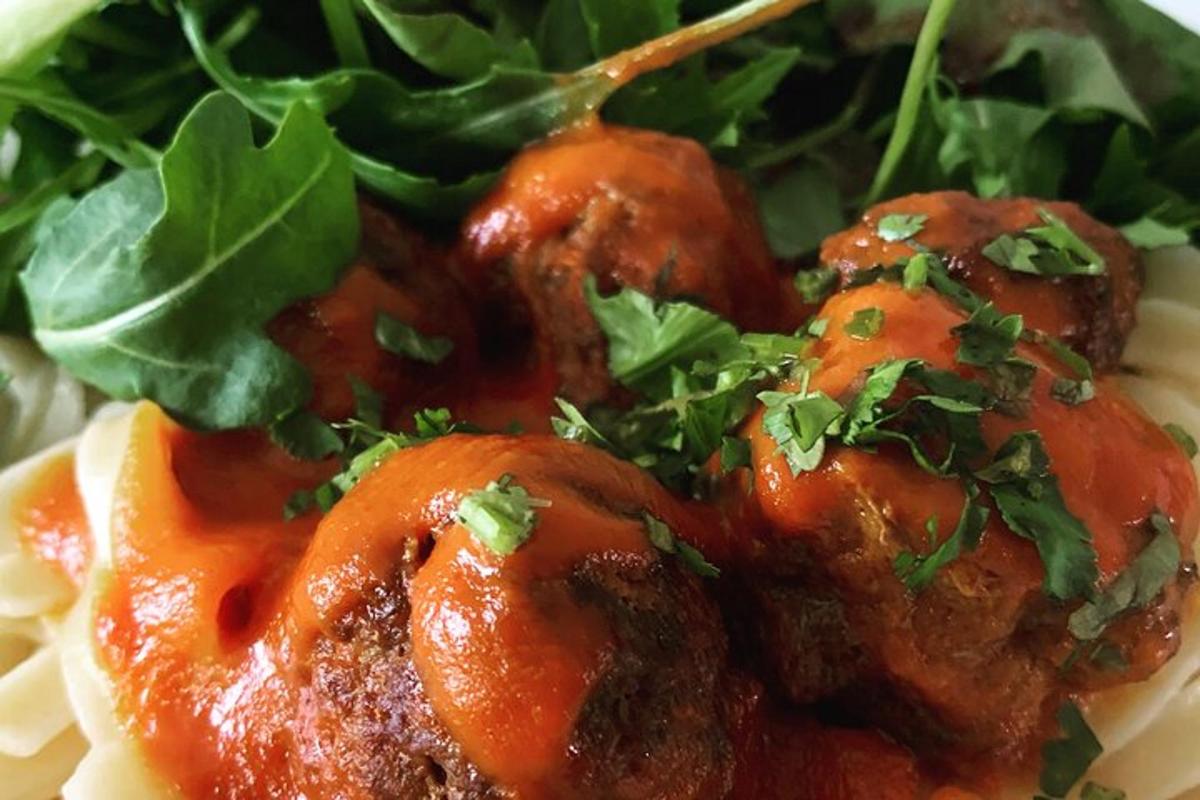 a plate of food with meatballs and greens