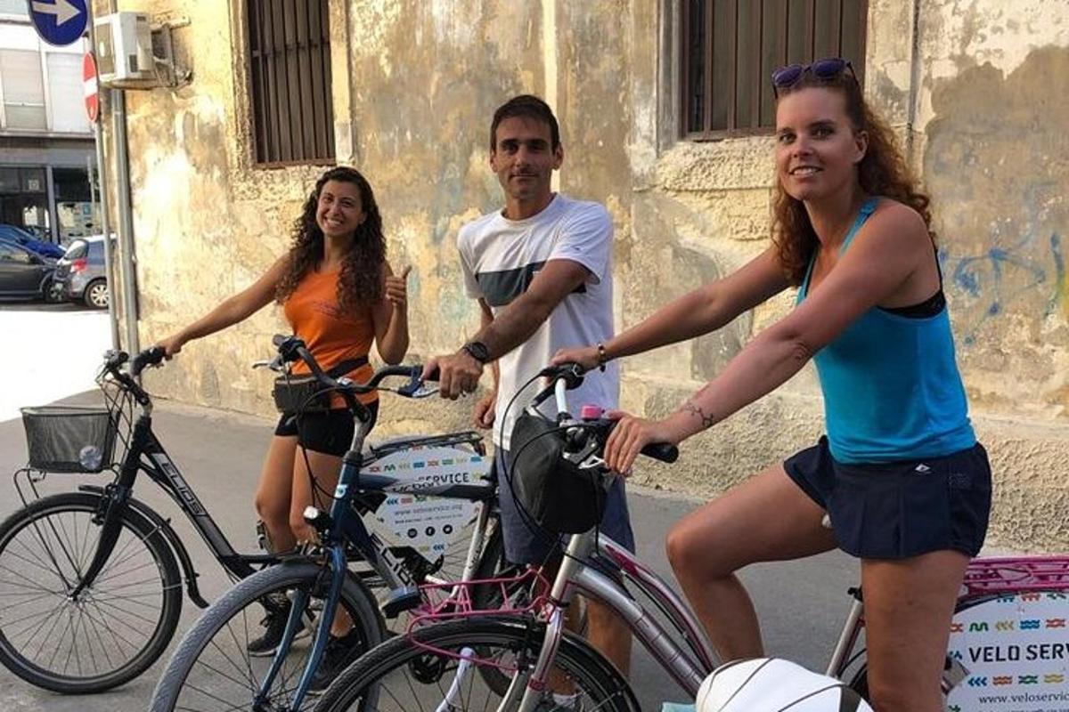 skupina treh ljudi, ki se vozijo s kolesi po ulici