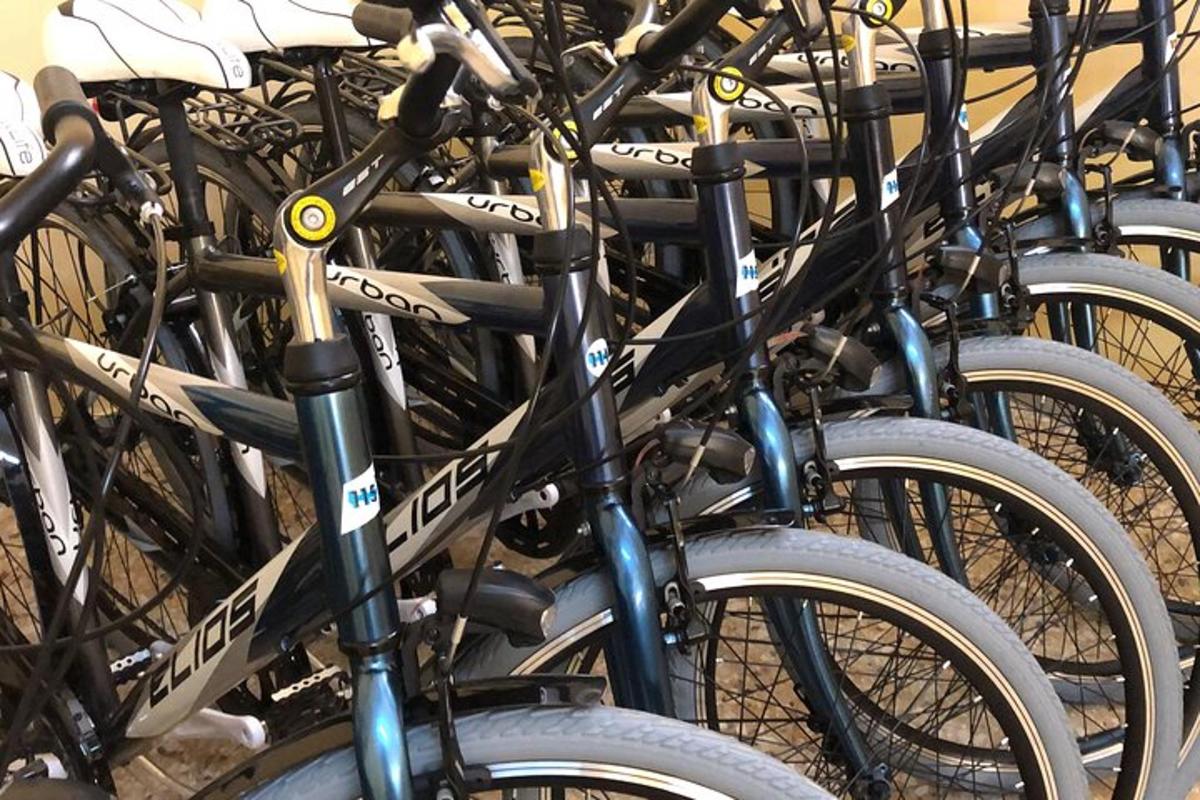 um monte de bicicletas estacionadas uma ao lado da outra