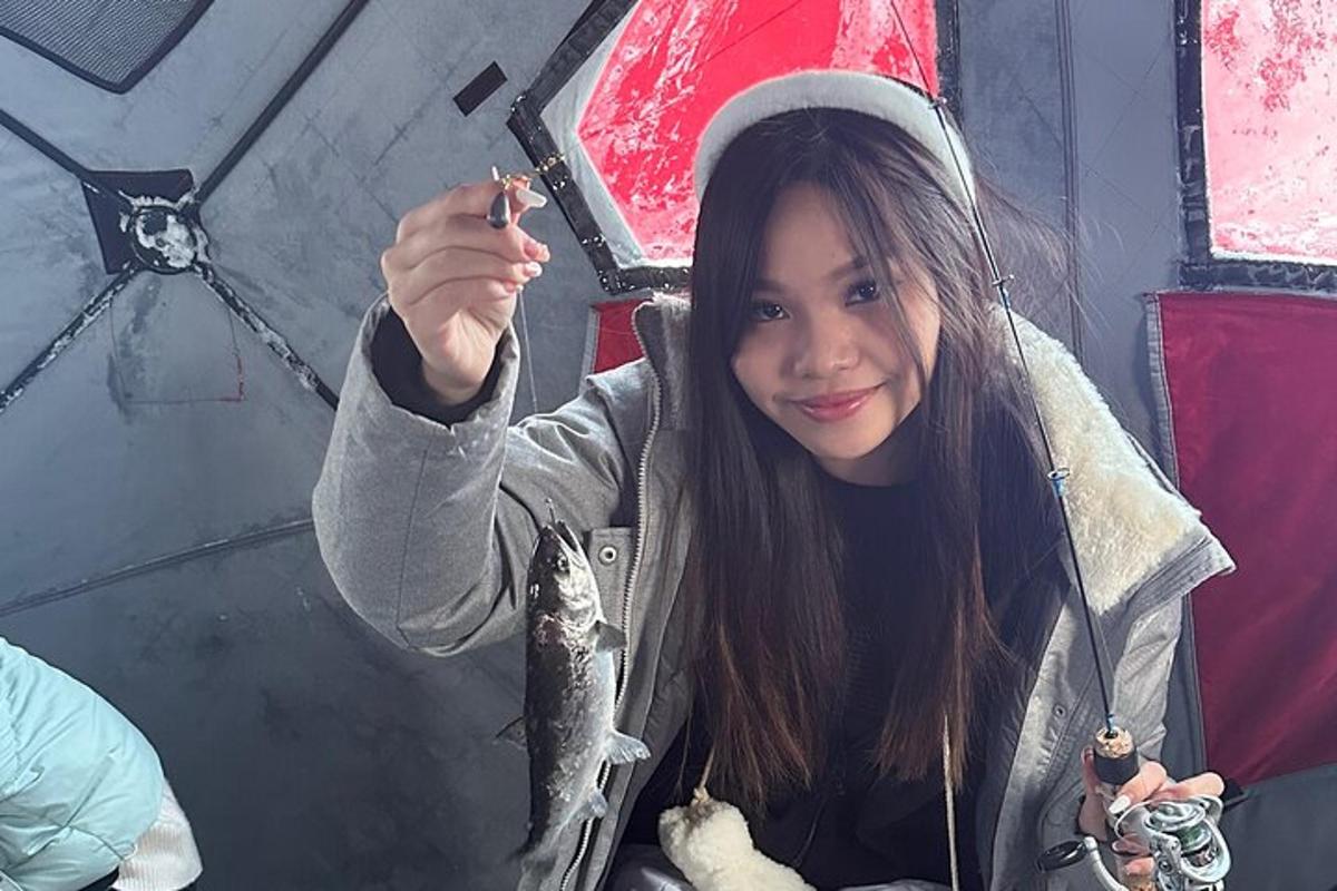 mladá dívka v santově čepici držící rybu