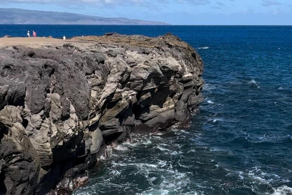 garis pantai berbatu dengan orang ramai di pantai dan lautan