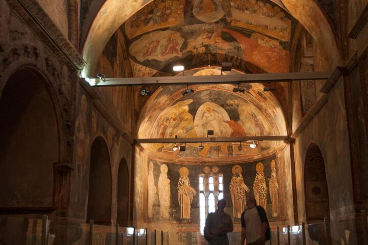 due persone in piedi davanti a una chiesa con un dipinto
