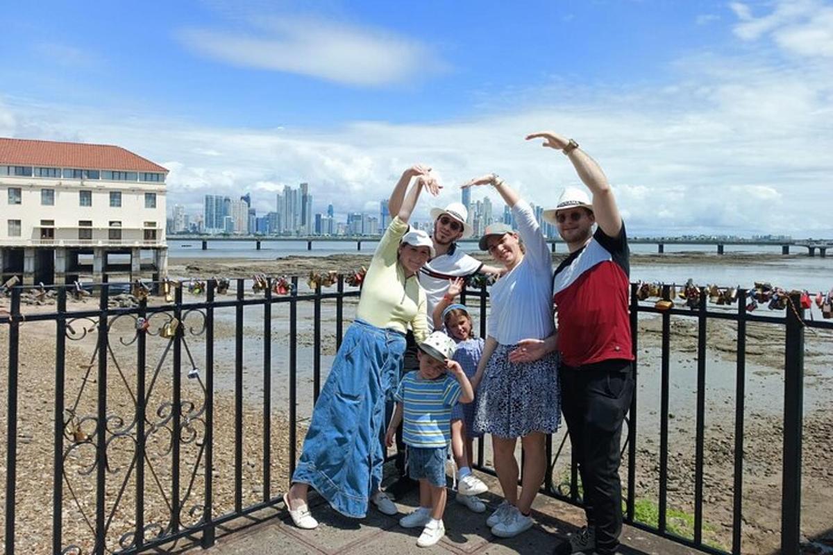 a family posing next to a fence at the beach