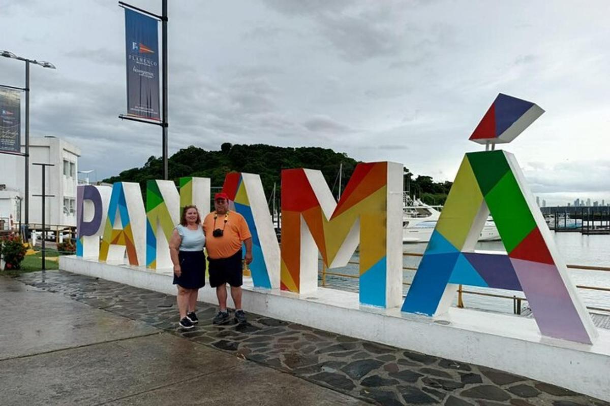 a man and a woman standing next to a colorful fence