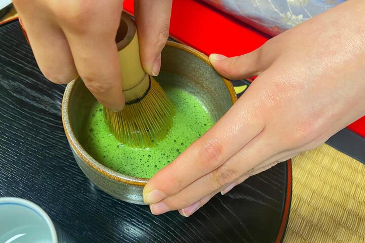 a person holding a brush in a pot with green liquid