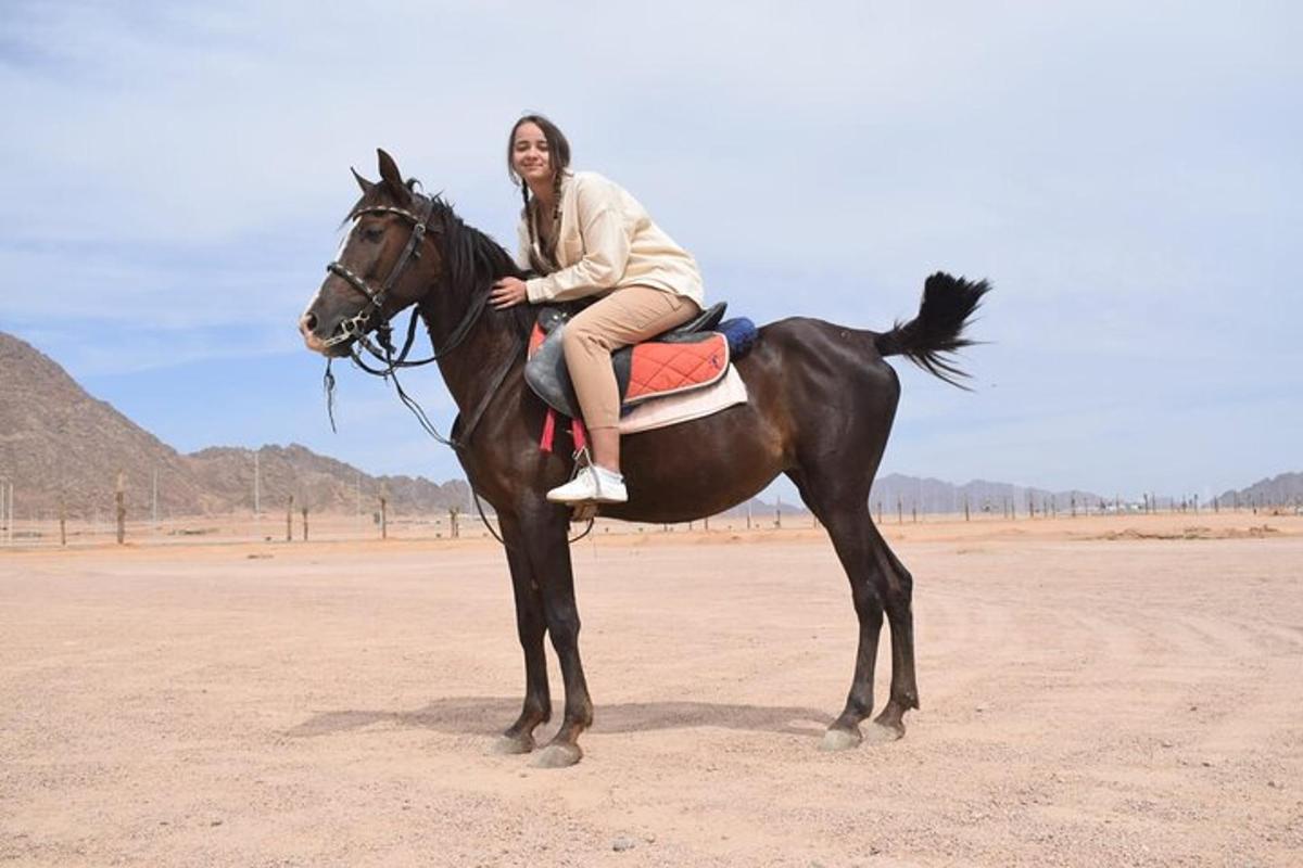 une femme assise sur un cheval dans le désert