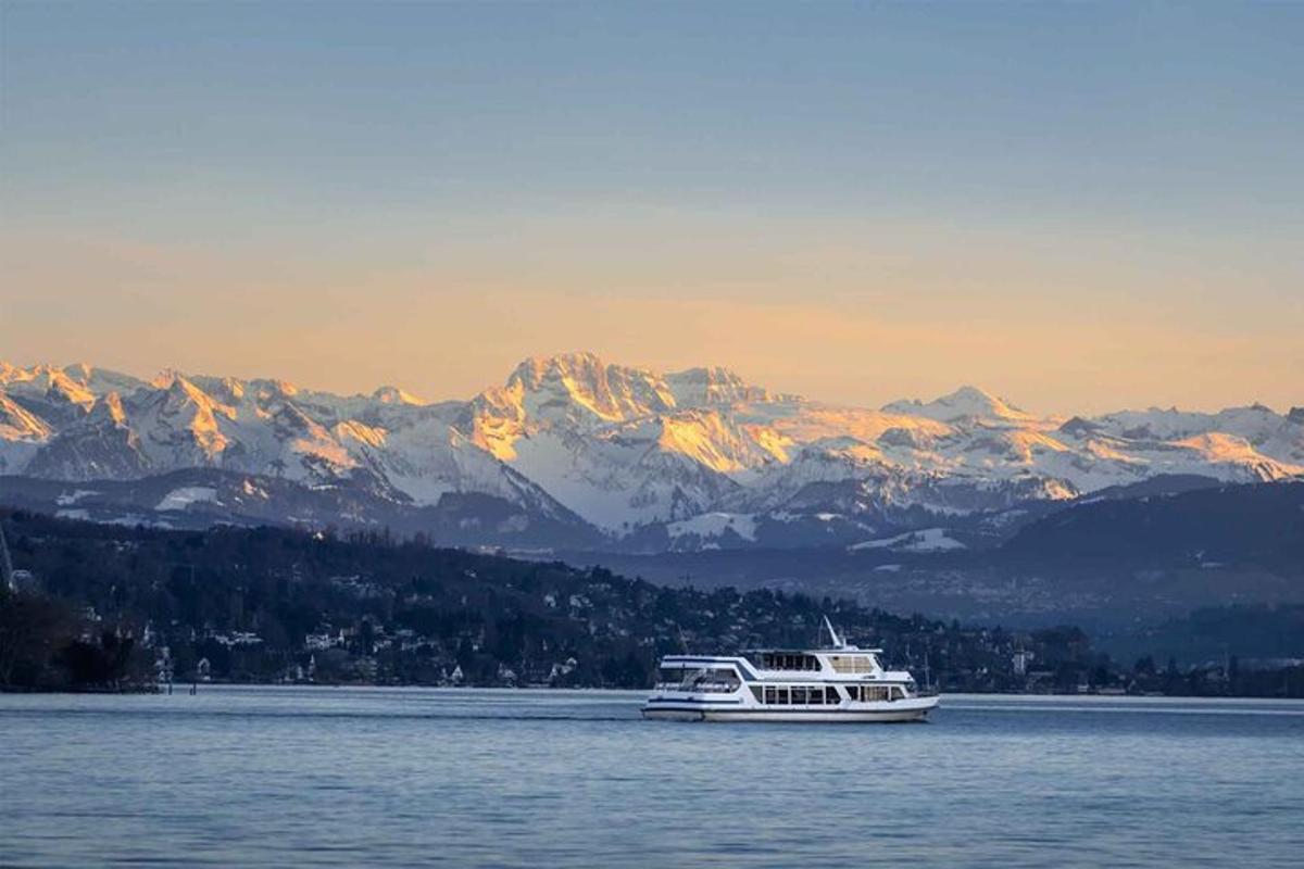 a boat on the water with mountains in the background
