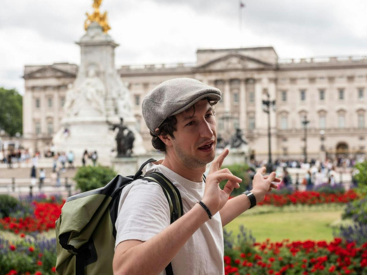 um homem com uma mochila em pé em frente a um prédio