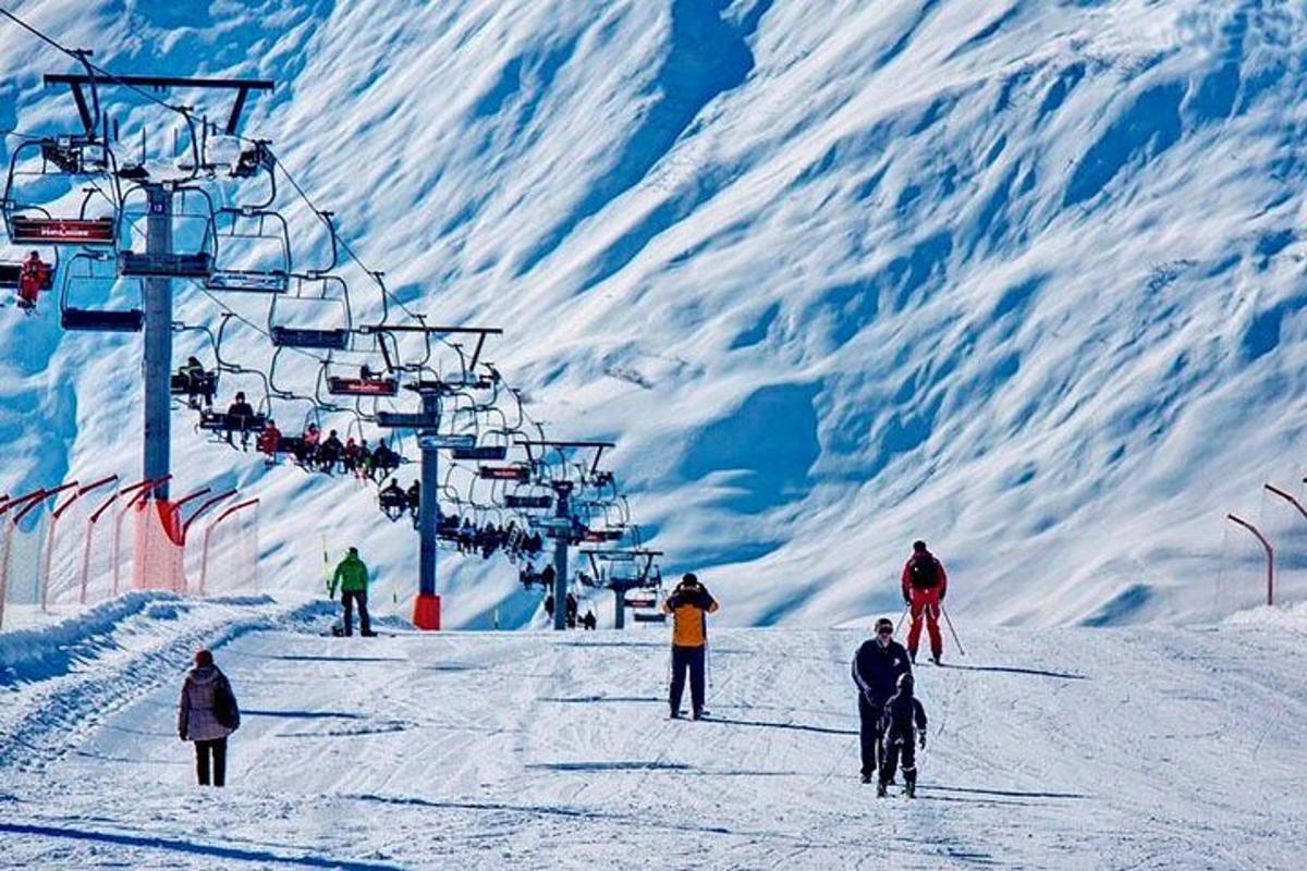 sekelompok orang di lift ski di salju