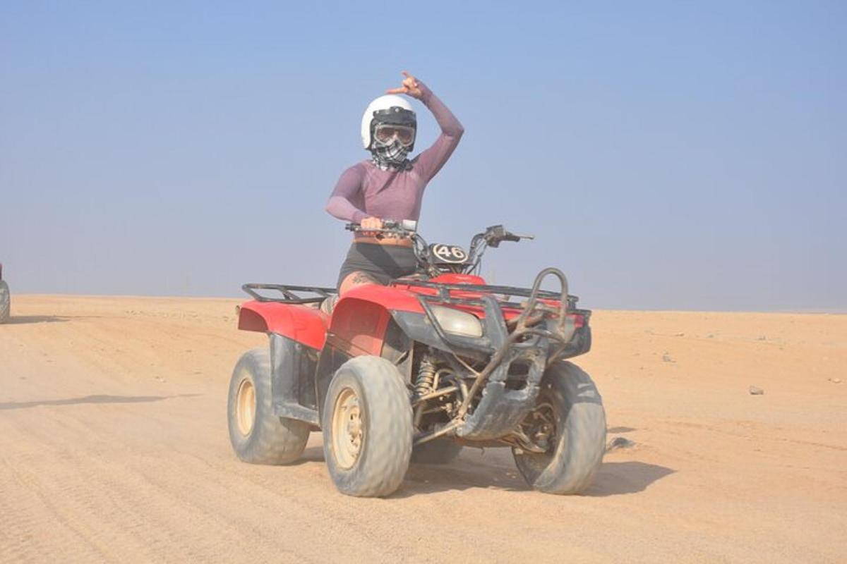 un bărbat care merge pe un ATV în deșert