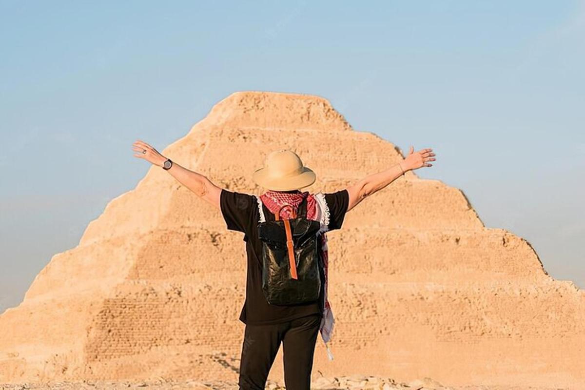 un uomo in piedi davanti a una piramide di sabbia