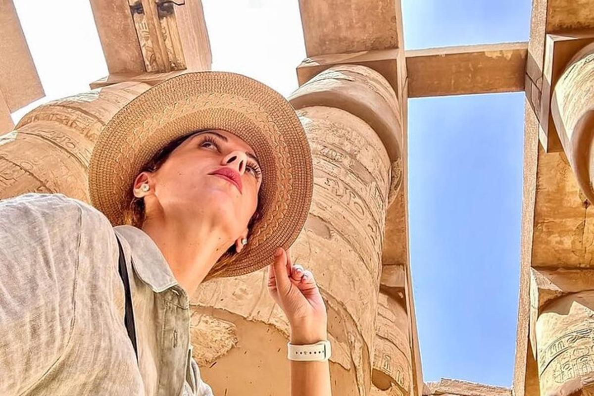 жена која носи шешир стоји испред зграде