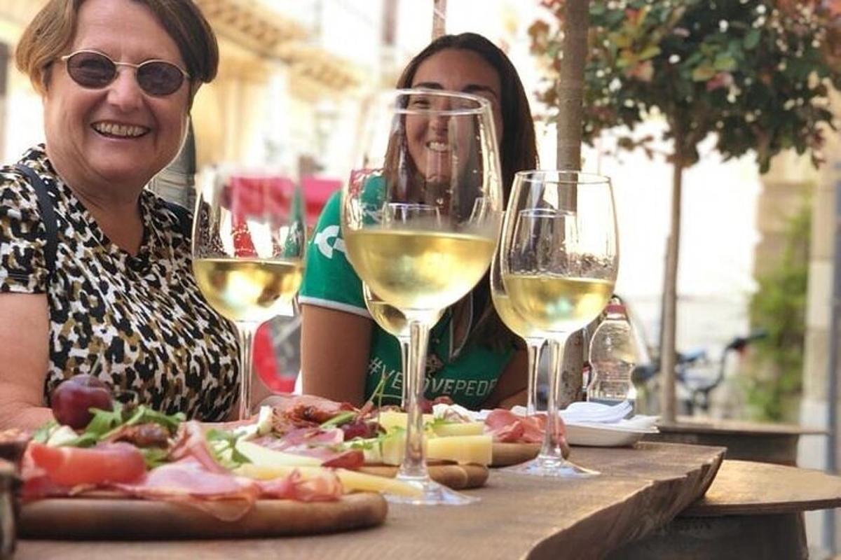 due donne sedute a un tavolo con bicchieri di vino