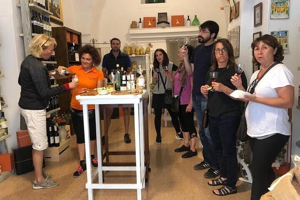un gruppo di persone in piedi in una stanza con bottiglie di vino